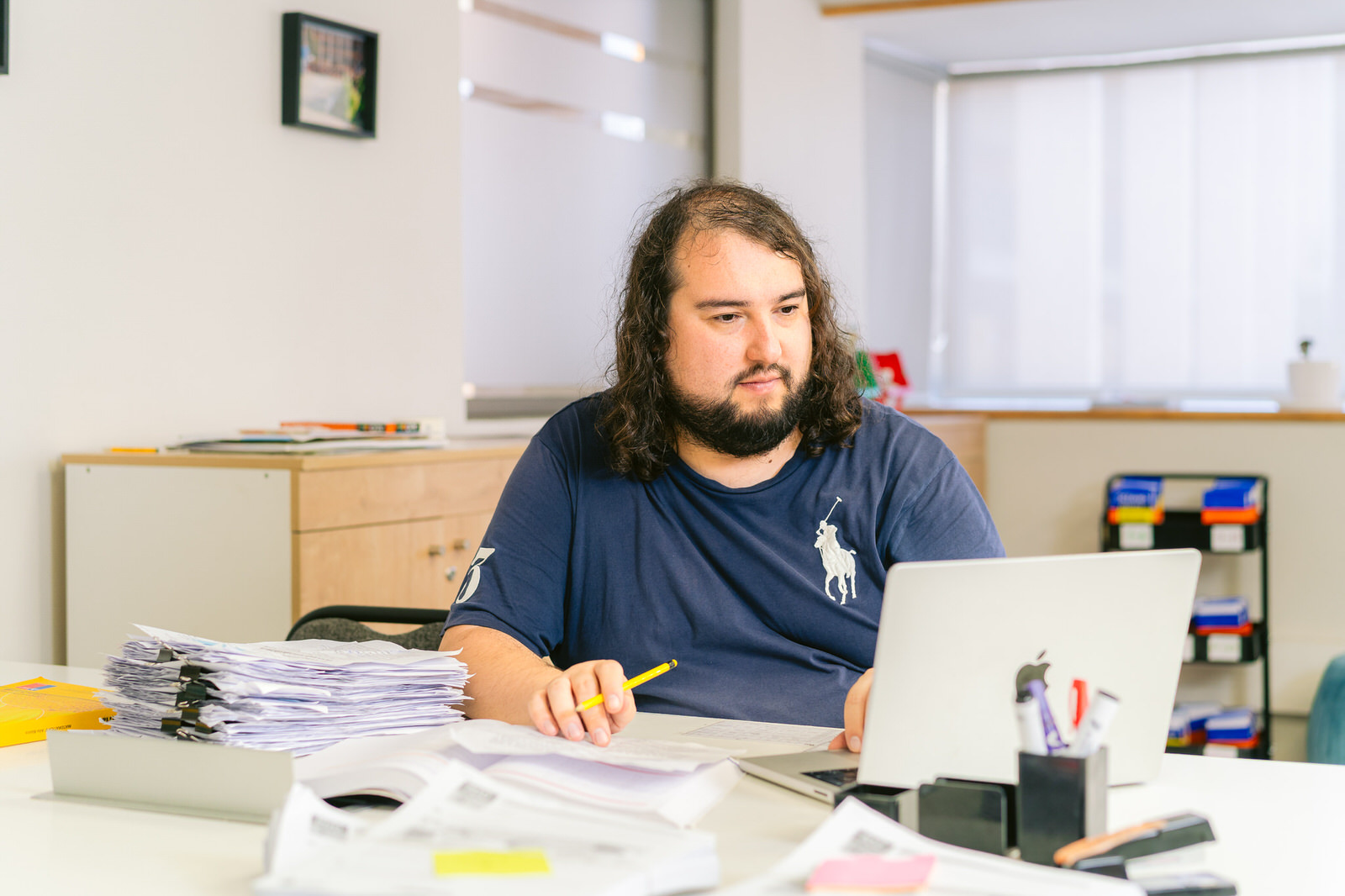 Hombre trabajando en escritorio con laptop y papeles — Elige Educar Mineduc