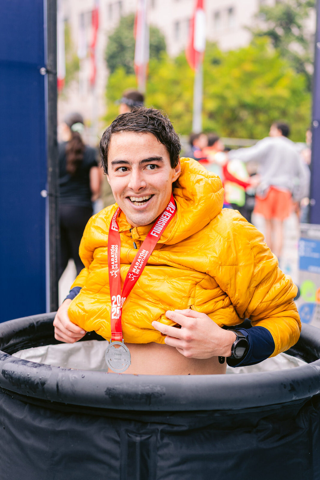 Maratón de Santiago 2025 — atleta sonriendo medalla chaqueta amarilla