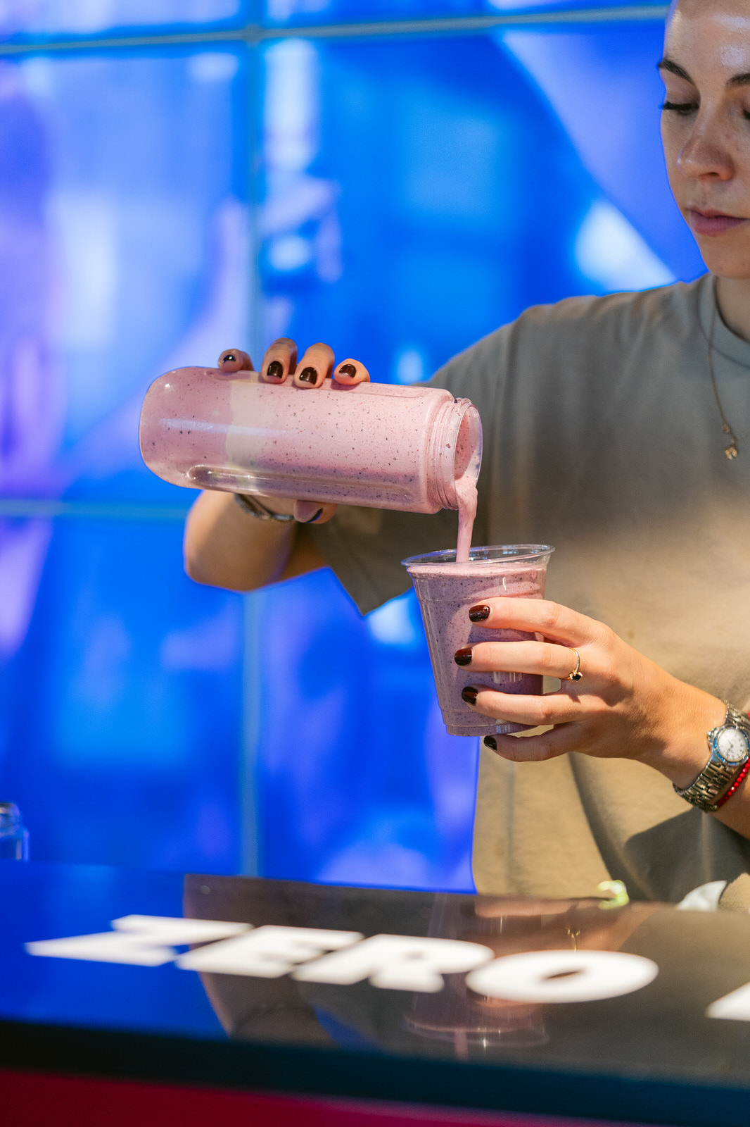 Red Bull RB Zero — batido rosa manos primer plano